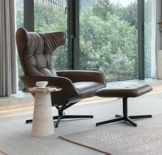 a chair and ottoman in front of a large window