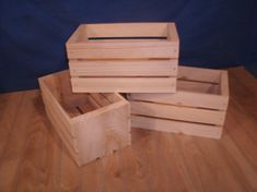 three wooden boxes stacked on top of each other in the middle of a wood floor