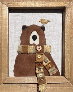 a brown teddy bear in a wooden frame with a bird on top of its head