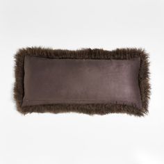 a rectangular pillow with faux fur trim on the bottom and sides, in dark brown