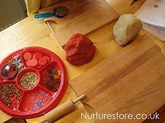 a wooden table topped with red plates filled with different types of food and utensils