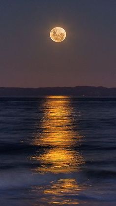 the moon is shining brightly over the water