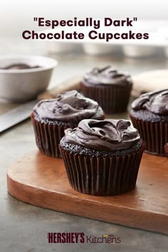 chocolate cupcakes with frosting on a wooden cutting board