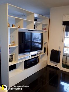 a living room with a large entertainment center and black tile flooring in front of a window