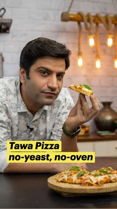 a man sitting at a table with a pizza in front of him