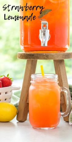 a mason jar filled with strawberry lemonade next to some strawberries and lemons