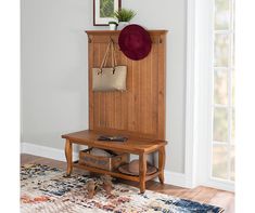 a wooden bench sitting in front of a wall with a hat on top of it