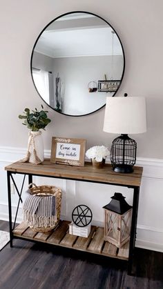 a wooden table topped with a mirror next to a lamp