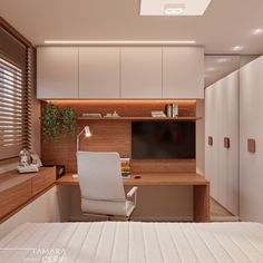 a bedroom with a bed, desk and television on the wall next to white cupboards