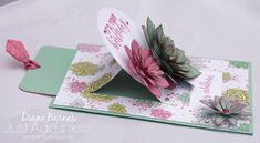 a close up of a greeting card on a table with paper flowers and cards attached to it