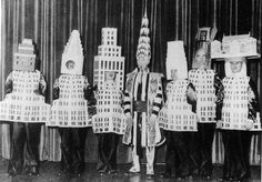 an old black and white photo of five people dressed in paper mache costumes, standing next to each other