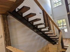 a wooden stair case with metal handrails in a house