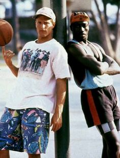 two men standing next to each other with basketballs on their hands and one holding a ball