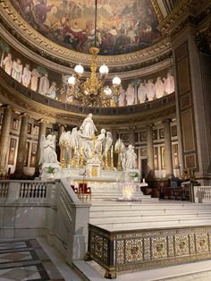 the interior of a church with statues and chandelier