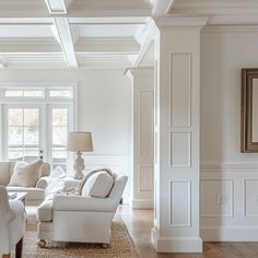 a living room with white furniture and wood floors