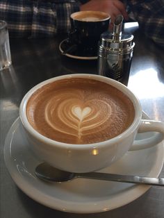 a cappuccino on a saucer with a heart drawn in the foam