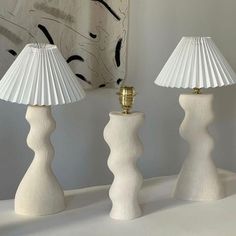 three white lamps sitting on top of a table