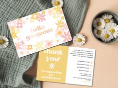 a thank card and some daisies on top of a blanket next to a potted plant