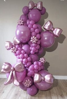 a bunch of balloons that are in the shape of a tower with bows on them