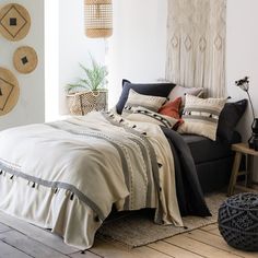 a bed sitting in a bedroom next to a wall with hanging baskets on it's sides