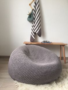 a knitted bean bag sitting on top of a wooden table next to a coat rack