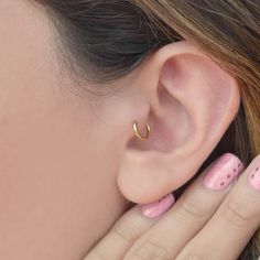 a woman's ear with pink and white polka dots on the outside of it