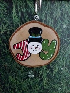 a wooden ornament with a snowman and cactus on it's side