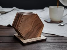 a wooden coaster sitting on top of a table next to a white cup and saucer