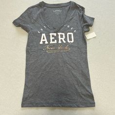 Brand New With Tags. Aeropostale V-Neck T-Shirt. Gray With Aero Logo. Size: Women X-Small Aeropostale Shirts, 2000s Fashion Outfits, 2000s Fashion, T Shirt Women, Aeropostale, Infant Tees, Vintage Y2k, V Neck T Shirt, Tights