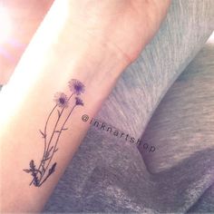 a woman's arm with a flower tattoo on the left side of her wrist