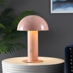 a pink lamp sitting on top of a white table