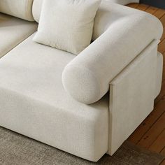 a white couch sitting on top of a wooden floor