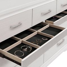 the drawers are full of jewelry and bracelets on display in this white dresser drawer