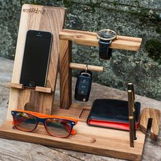 a wooden stand with glasses, cell phone and other items on it that includes a watch