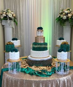 a three tiered cake sitting on top of a table covered in green and gold