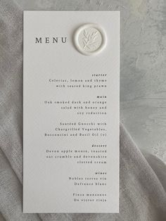 a menu card with a button on it sitting next to a piece of paper that says menu