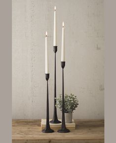 three candles are sitting on a wooden table