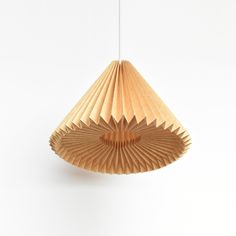 a wooden lamp hanging from a string on a white wall