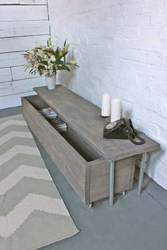 a coffee table with two drawers on it and a rug next to it in front of a white brick wall