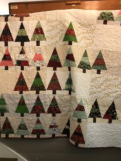 a quilted christmas tree is hanging on the wall