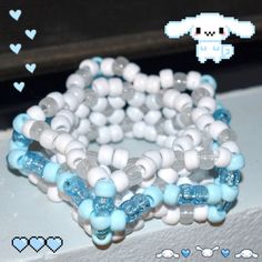 several bracelets with blue and white beads on top of each other in front of a window