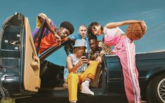 a group of young people sitting in the back of a car with basketballs on their feet