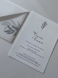 the wedding card is laying on top of an envelope and it has a watercolor leaf design