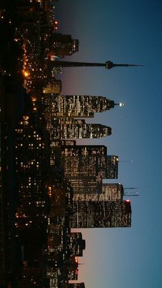 the skyline of new york city at night with skyscrapers lit up in the background