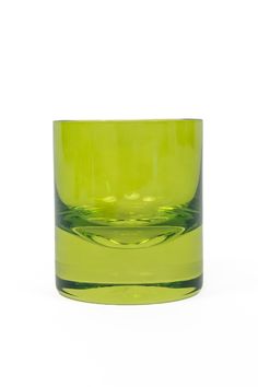 a green glass cup sitting on top of a white table