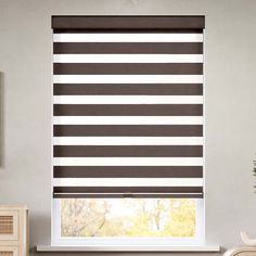 a living room with a window covered in black and white striped blind shades on the windowsill