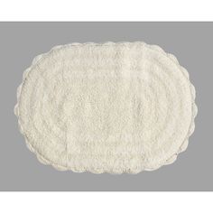 a white round rug with scalloped edges on a gray background, in the shape of an oval