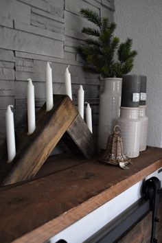 some candles are sitting on top of a wooden shelf