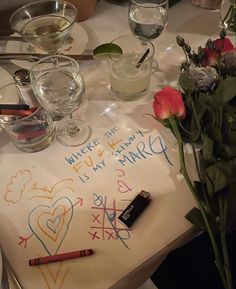 the table is set with flowers, candles and writing on paper that says where it is my birthday