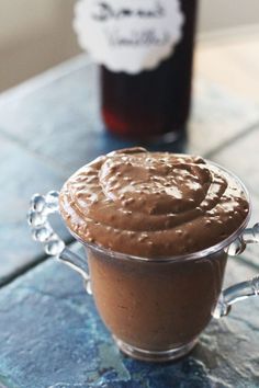 a glass container filled with chocolate spread on top of a table